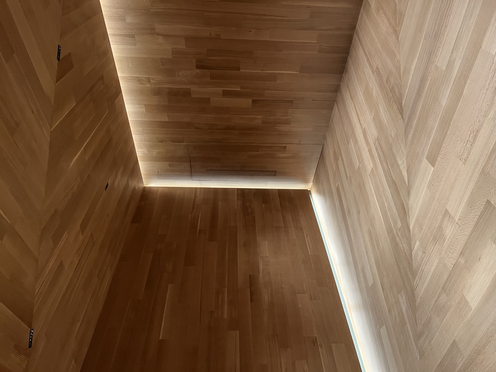 Custom chevron hardwood floor with matching wood-paneled walls and ceiling